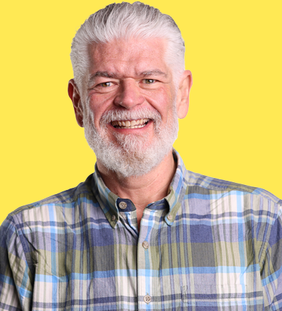 Smiling older man with gray beard in plaid shirt at marketing conference 2026
