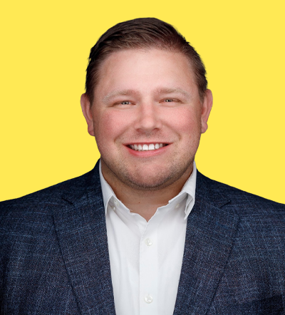Man in suit smiles on yellow background, Smart Marketer LIVE 2026