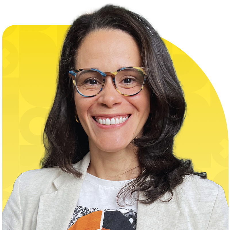 Woman with glasses smiling against a yellow background
