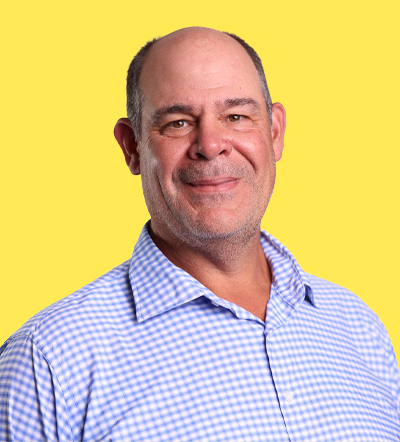 Bald man with a friendly smile wearing a blue and white checkered shirt
